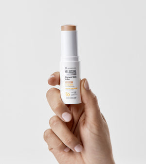 HELIOCARE 360 Pigmentinis pieštukas SPF50, Beige atspalvis – atviras pieštukas rankoje, matoma beige spalvos tekstūra